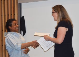 Prof. Kelly Burke presents Rumesha Pererage with third place prize at the 2024 poster session
